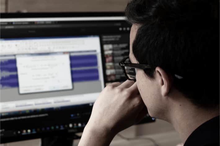 Hombre con gafas mirando una ventana emergente en la pantalla de su computadora