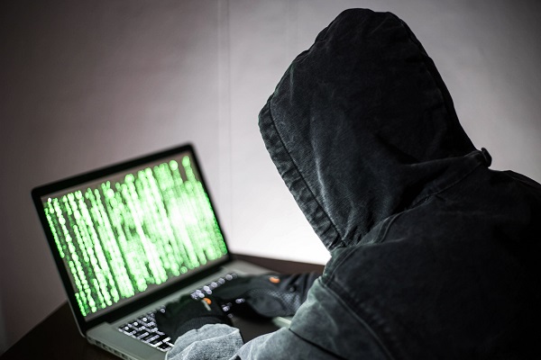 Un hombre trabajando en su computadora se frustra al darse cuenta de que es víctima de un pirateo